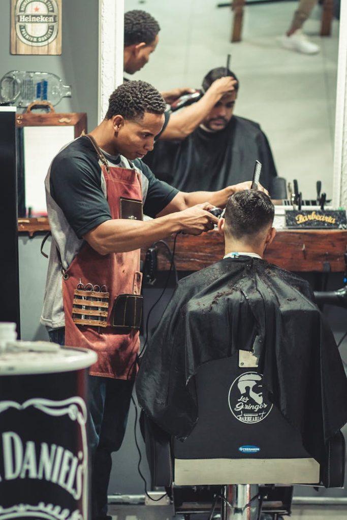 Barber skillfully cutting hair in a trendy barbershop with modern decor and relaxed atmosphere.